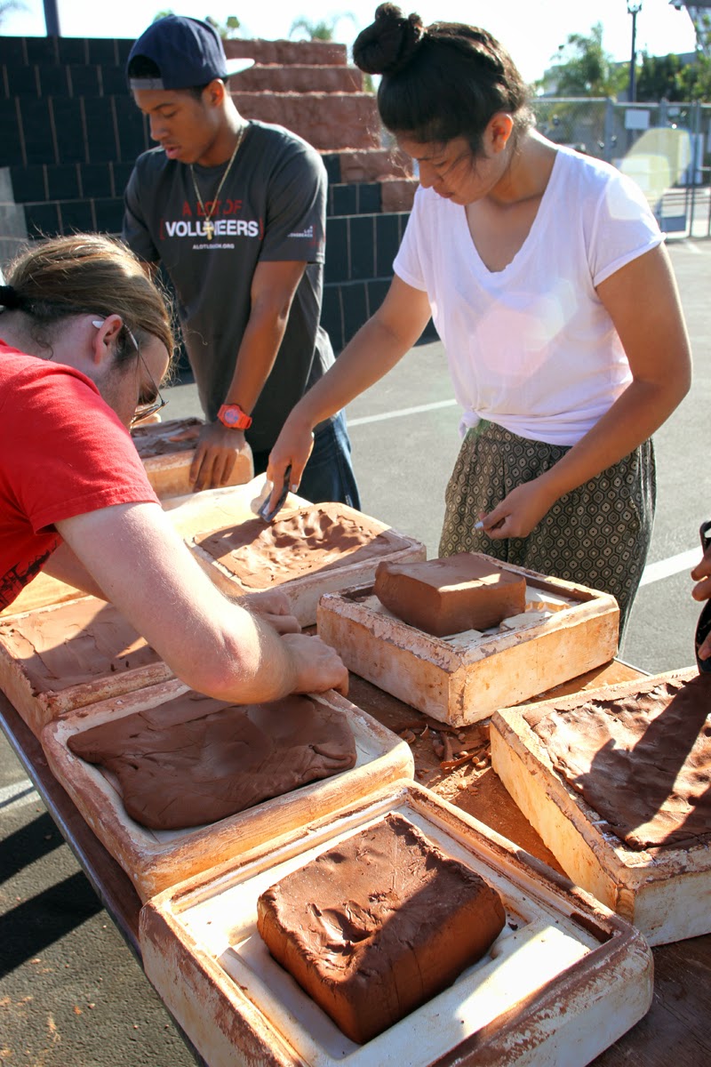 Participants putting clay into molds